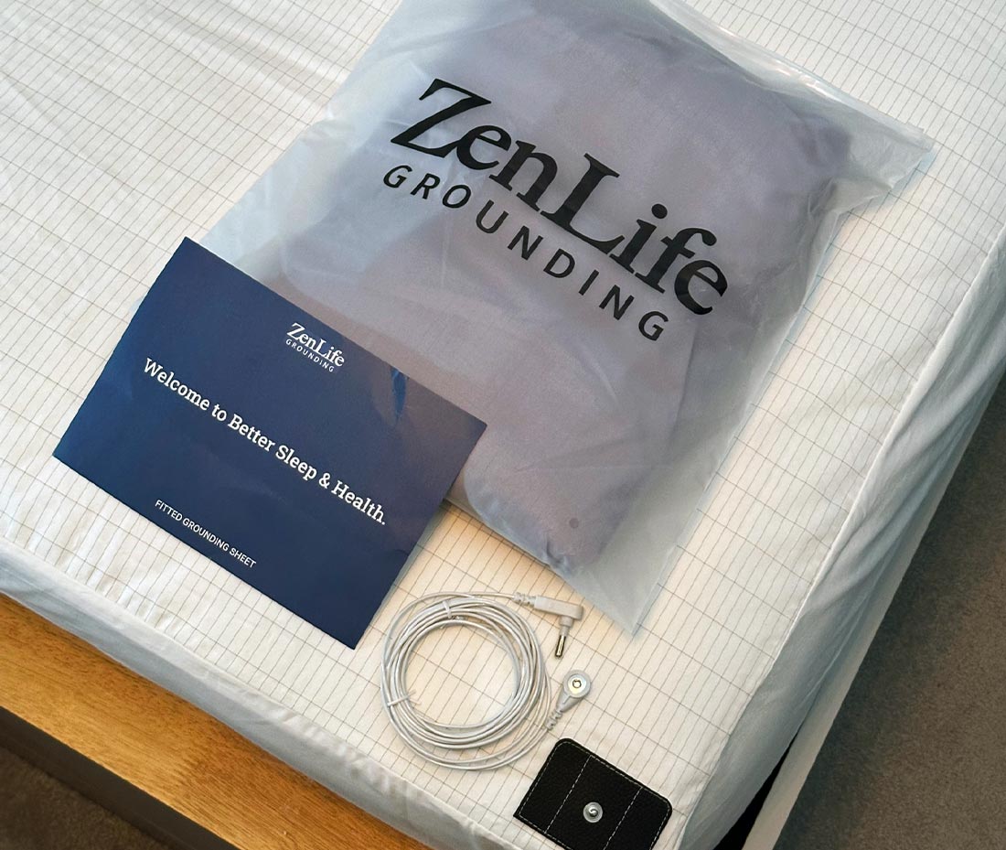 ZenLife Grounding sleep kit with a bag, manual, and grounding cord on a bed.